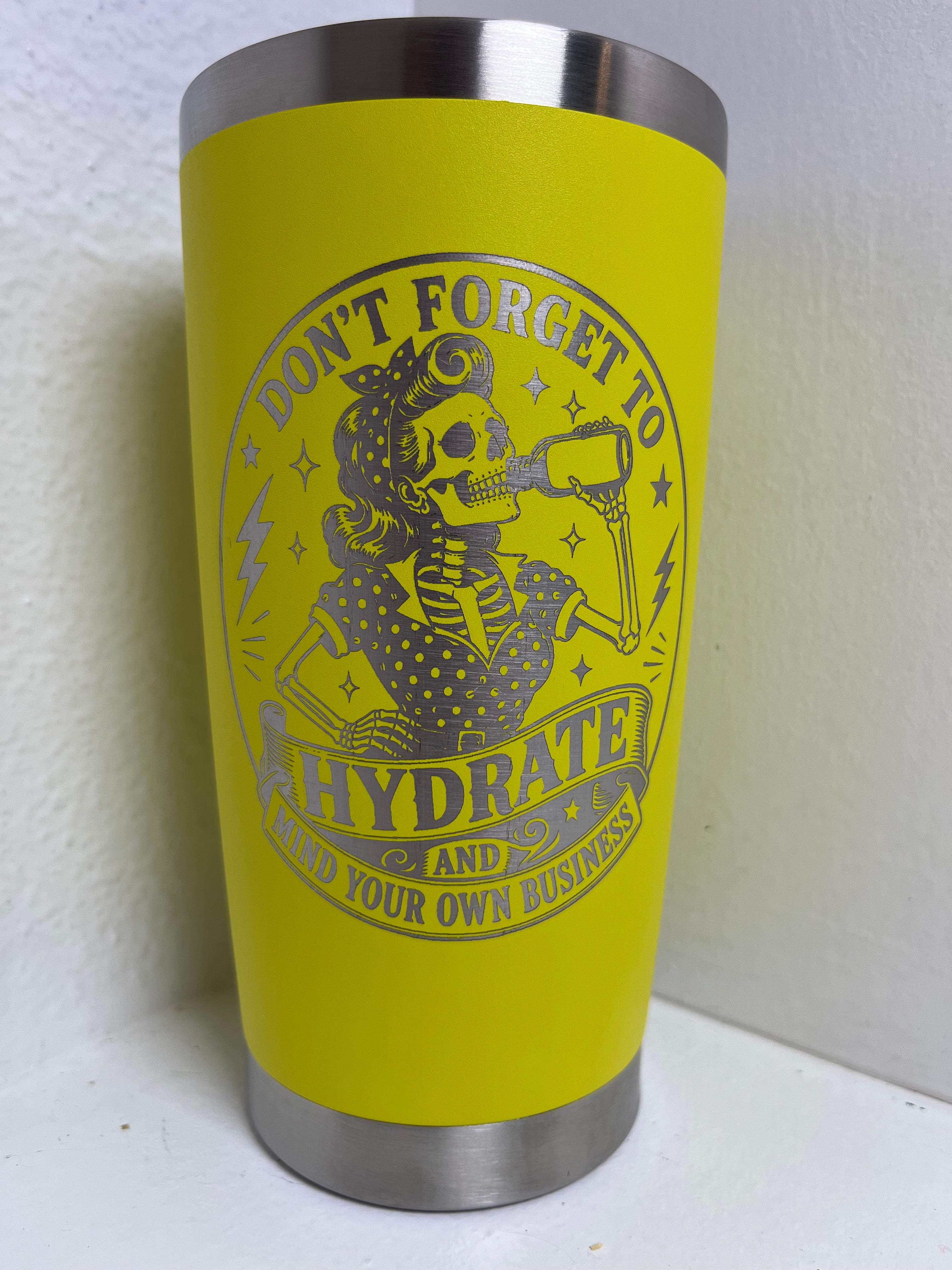 Yellow tumbler with a skull design and text 